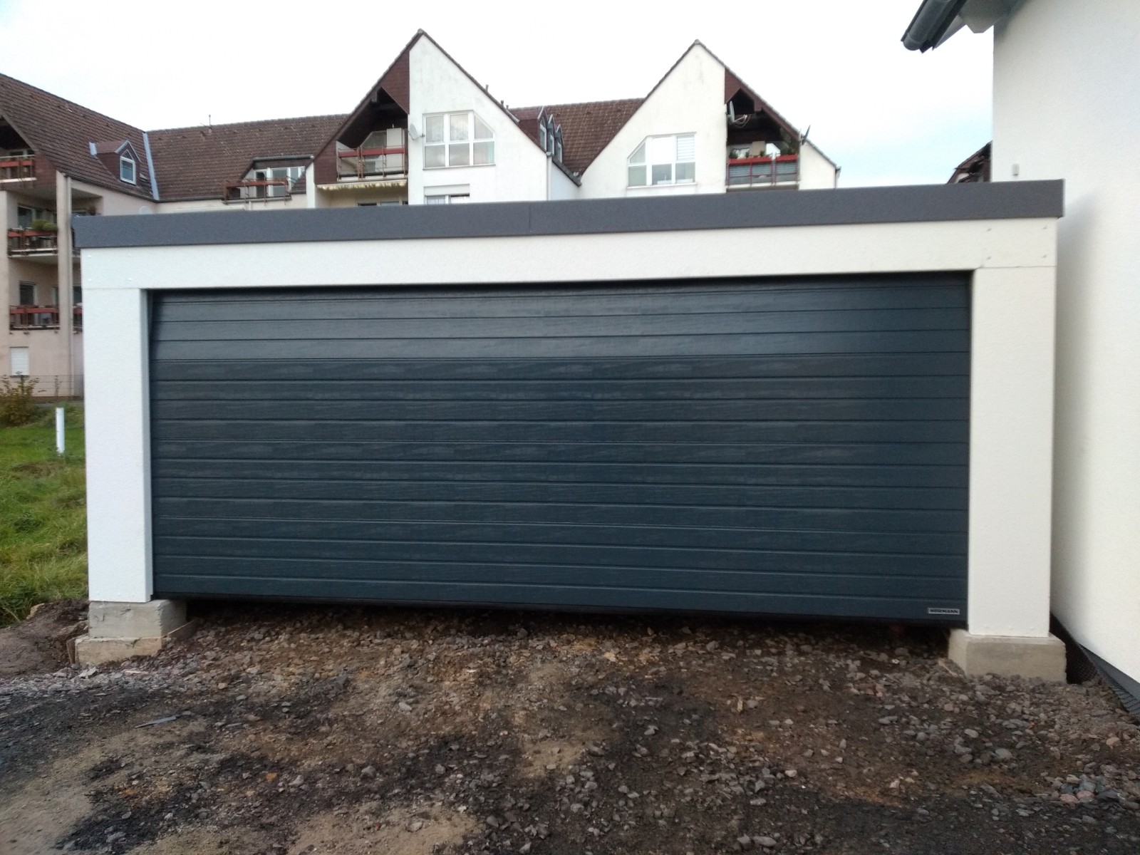 Großraumgarage Glattwand weiß mit anthrazitem Sektionaltor